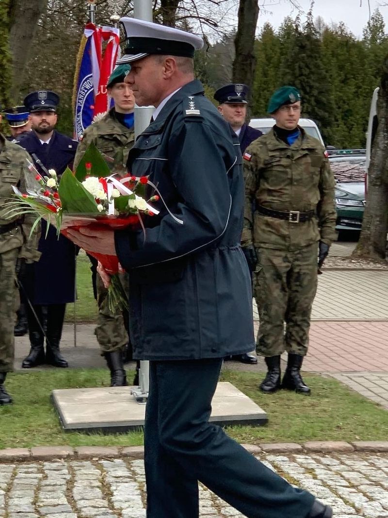 Dyrektor WITD Olsztyn składa kwiaty przed pomnikiem katyńskim